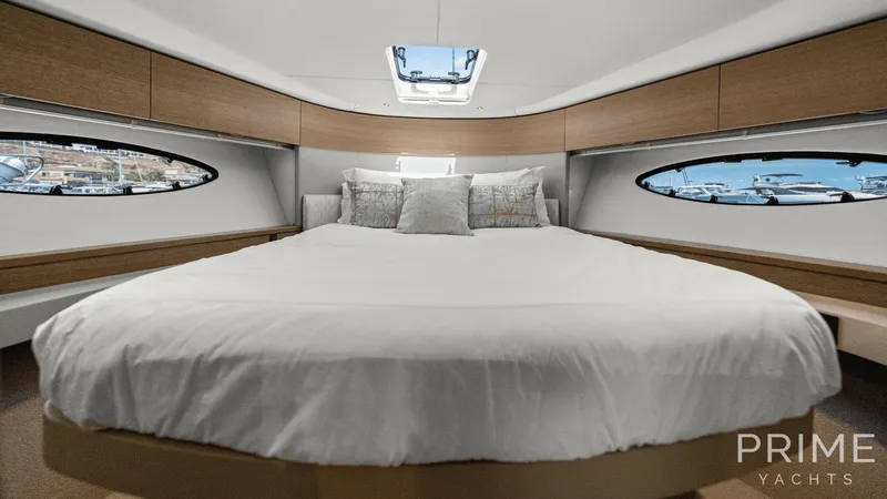  Yacht Photos Pics Luxurious cabin interior of 2019 Princess F49 yacht with elegant bedding and porthole views.