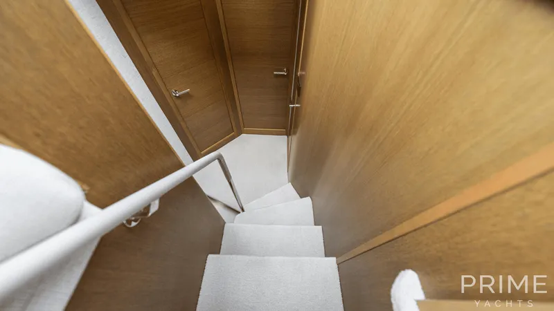  Yacht Photos Pics Staircase inside 2019 Princess F49 yacht with wooden walls and carpeted steps.