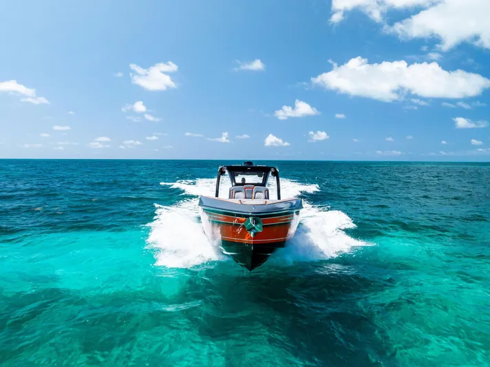 Casual Acquaintance Yacht Photos Pics 2024 Deep Impact 399 Sport boat cruising on clear turquoise ocean waters.