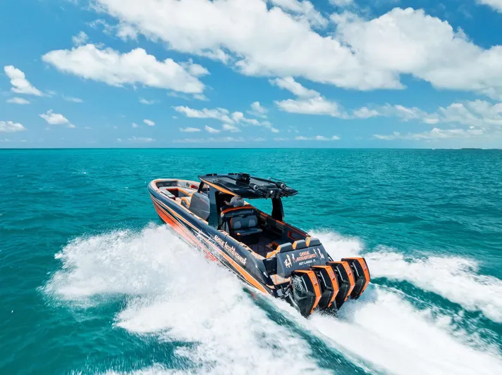 Casual Acquaintance Yacht Photos Pics 2024 Deep Impact 399 Sport boat speeding on turquoise ocean under blue sky.