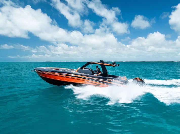 Casual Acquaintance Yacht Photos Pics 2024 Deep Impact 399 Sport boat cruising on turquoise ocean under clear blue sky.