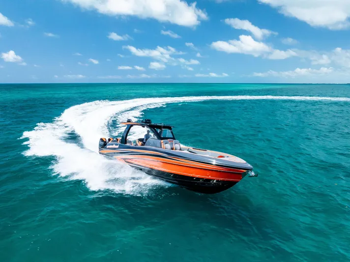 Casual Acquaintance Yacht Photos Pics 2024 Deep Impact 399 Sport boat cruising on clear blue ocean waters.