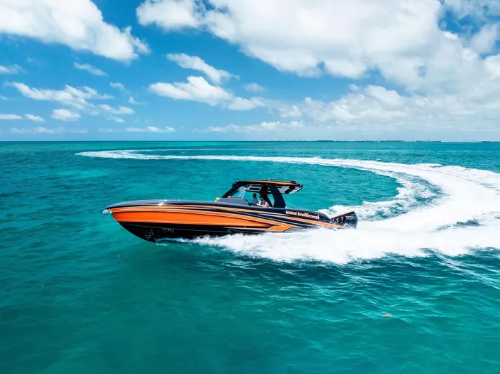 Casual Acquaintance Yacht Photos Pics 2024 Deep Impact 399 Sport boat cruising on turquoise ocean under clear blue sky.