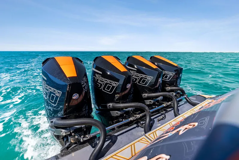 Casual Acquaintance Yacht Photos Pics 2024 Deep Impact 399 Sport boat with four powerful outboard engines on turquoise water.