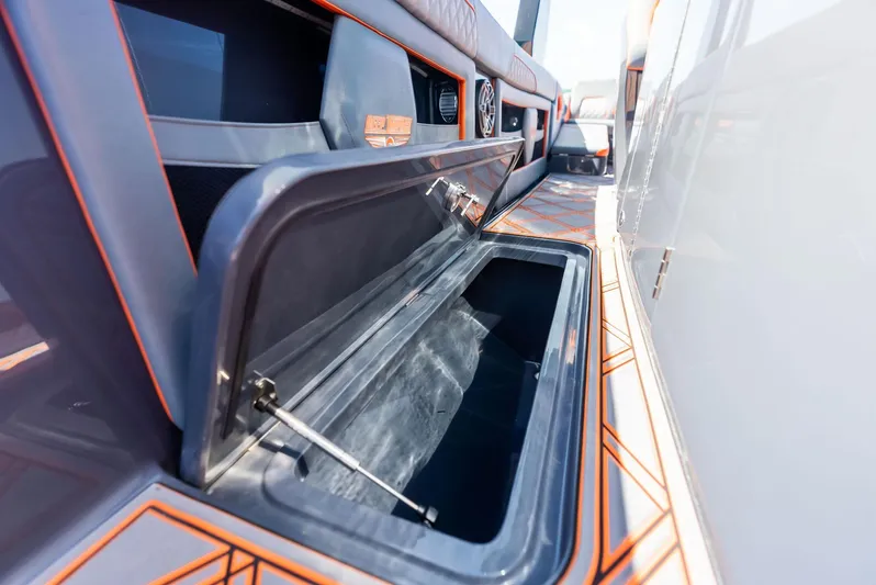 Casual Acquaintance Yacht Photos Pics 2024 Deep Impact 399 Sport boat storage compartment with sleek design and orange accents.