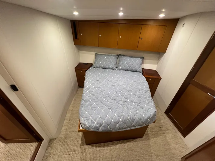  Yacht Photos Pics Cozy bedroom in 2001 Ocean 52 Convertible yacht with wooden cabinets and soft lighting.