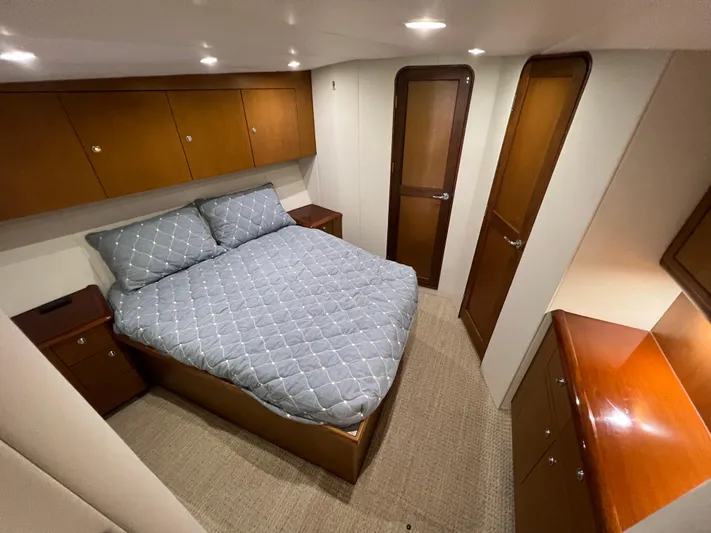  Yacht Photos Pics Luxurious bedroom in 2001 Ocean 52 Convertible yacht with wood cabinetry and cozy bedding.