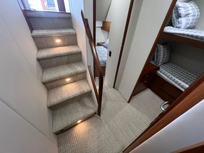  Yacht Photos Pics Interior of 2001 Ocean 52 Convertible yacht with carpeted stairs and cozy sleeping area.