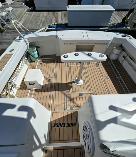 Side Chick Yacht Photos Pics Deck of a 2002 Rampage 38 Express boat with wooden flooring.