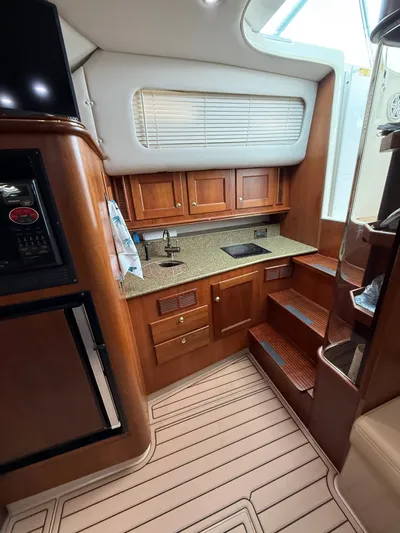 Side Chick Yacht Photos Pics Interior of 2002 Rampage 38 Express with wood cabinetry and kitchenette.