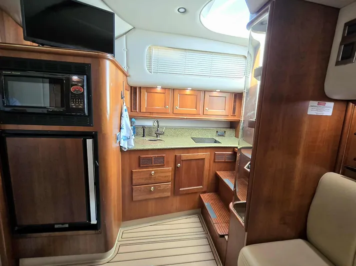 Side Chick Yacht Photos Pics Interior of 2002 Rampage 38 Express with kitchen and wood finish.