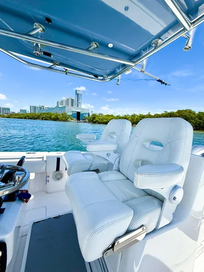 Relentless II W/ Seakeeper Yacht Photos Pics 2017 Contender 35 ST boat with white seating, blue canopy, and scenic waterfront view.