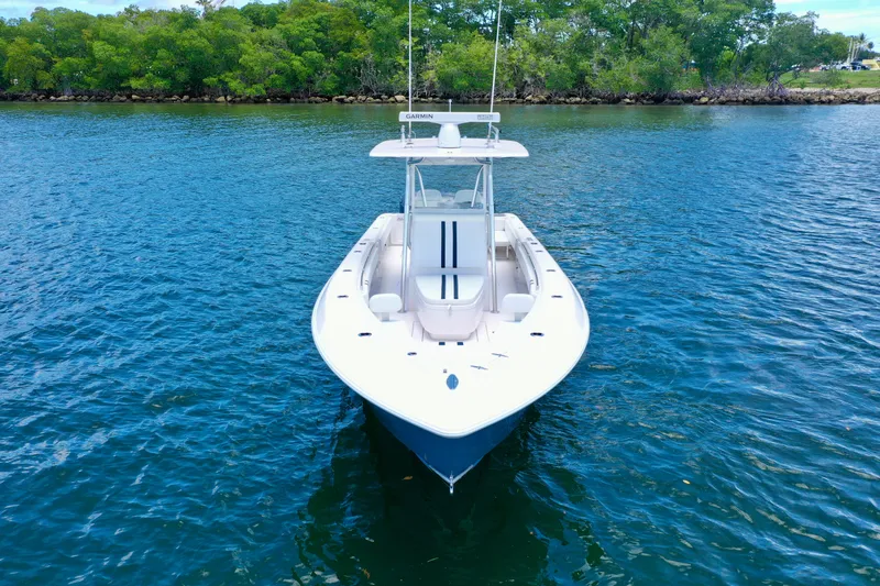 Relentless II W/ Seakeeper Yacht Photos Pics 2017 Contender 35 ST boat on calm water, surrounded by lush greenery.