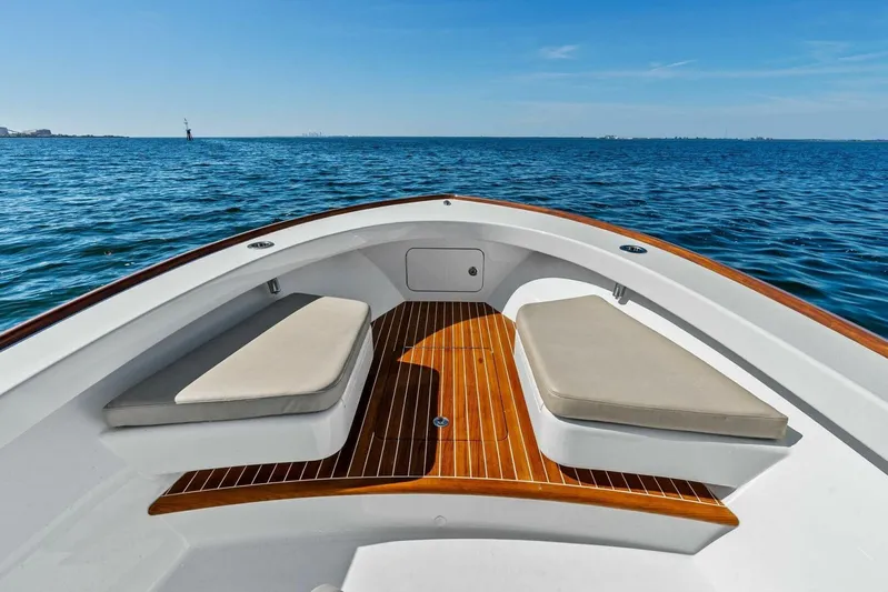  Yacht Photos Pics 2024 Custom Center Console High Ground Boatworks on open water, featuring cushioned seating and wooden deck.