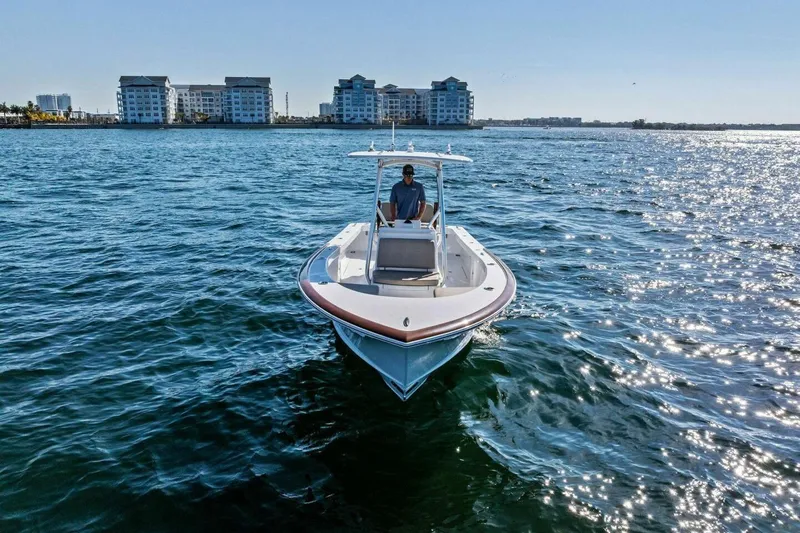  Yacht Photos Pics 2024 Custom Center Console High Ground Boatworks on sparkling water near coastal buildings.