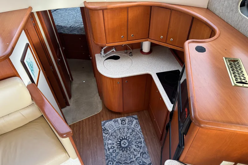 Stormer Yacht Photos Pics 2005 Silverton 34 Convertible yacht interior with wood cabinetry and compact kitchen layout.