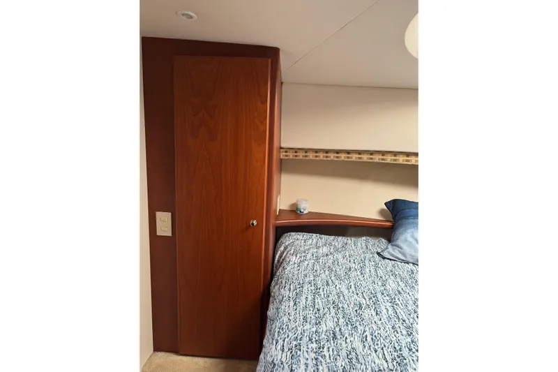Stormer Yacht Photos Pics 2005 Silverton 34 Convertible cabin interior with wooden door and cozy bed.