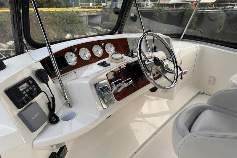 Stormer Yacht Photos Pics 2005 Silverton 34 Convertible boat helm with steering wheel and control panel.