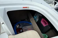 Storage compartment of a 2007 Cobalt 232 boat with various items inside.