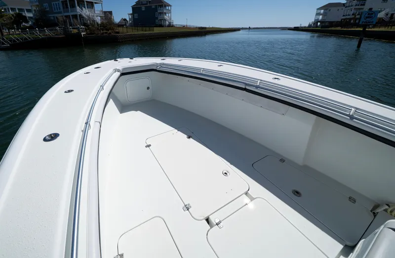  Yacht Photos Pics 2018 Yellowfin 32 Offshore boat on calm water, showcasing spacious deck and sleek design.