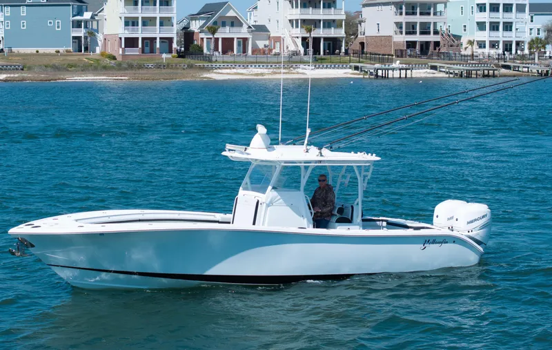  Yacht Photos Pics 2018 Yellowfin 32 Offshore boat cruising near coastal homes.