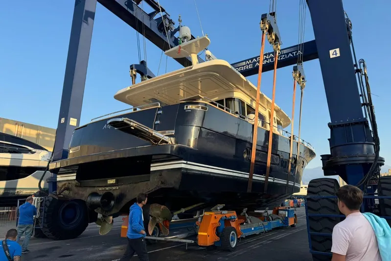  Yacht Photos Pics 2008 Apreamare Maestro 65 yacht being lifted at a marina with workers nearby.