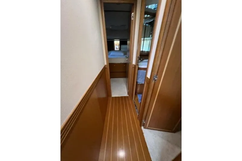  Yacht Photos Pics Narrow hallway inside 2008 Apreamare Maestro 65 yacht, featuring wooden flooring and cabin doors.