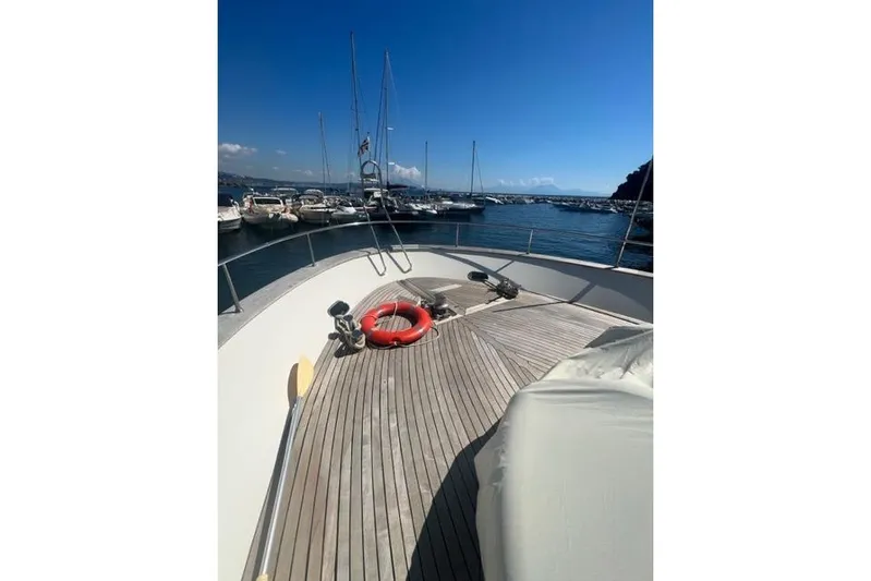  Yacht Photos Pics 2008 Apreamare Maestro 65 yacht deck with lifebuoy, docked in a marina under clear blue skies.