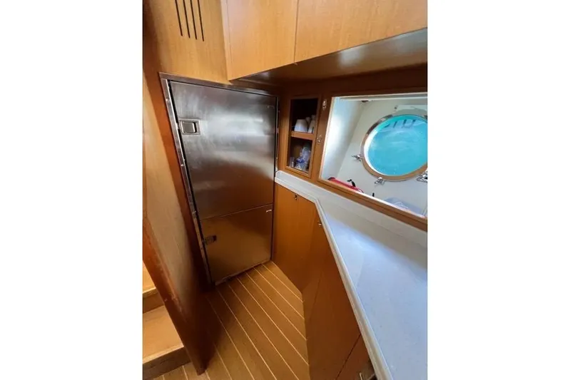  Yacht Photos Pics Interior of 2008 Apreamare Maestro 65 yacht with wooden cabinetry and porthole window.