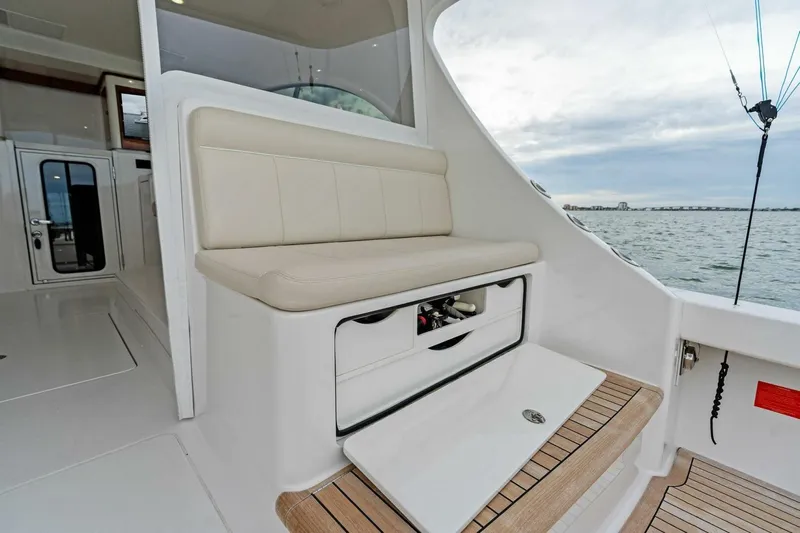 Damfino Yacht Photos Pics 2021 Viking 46 Billfish boat interior with cushioned seating and storage, overlooking the water.