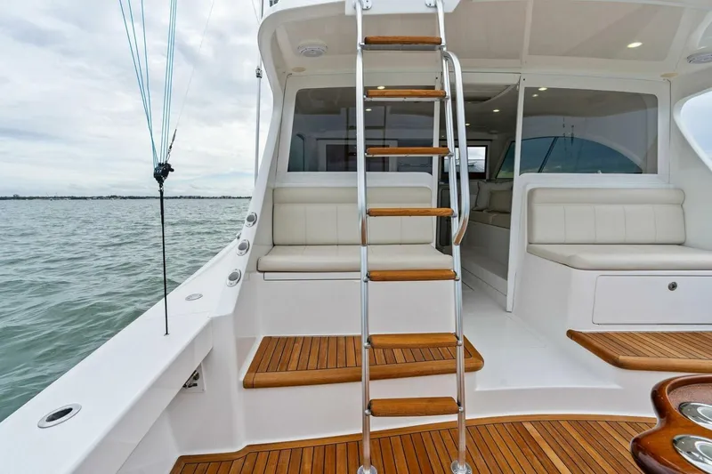 Damfino Yacht Photos Pics 2021 Viking 46 Billfish yacht interior with wooden steps and seating, overlooking the ocean.