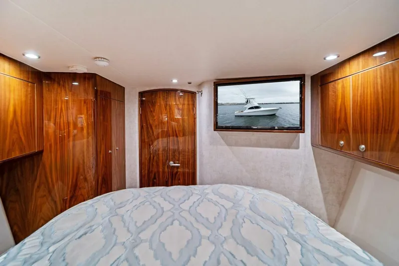 Damfino Yacht Photos Pics Luxurious cabin interior of 2021 Viking 46 Billfish yacht with wood paneling and bed.