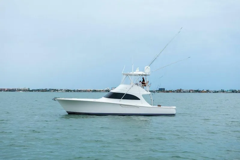 Damfino Yacht Photos Pics 2021 Viking 46 Billfish yacht cruising on calm waters near a coastal city.