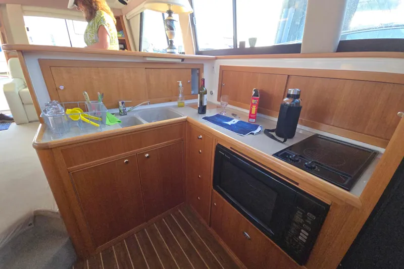 Buenos Aires Yacht Photos Pics 2003 Riviera 48 Flybridge yacht kitchen with wooden cabinetry and modern appliances.