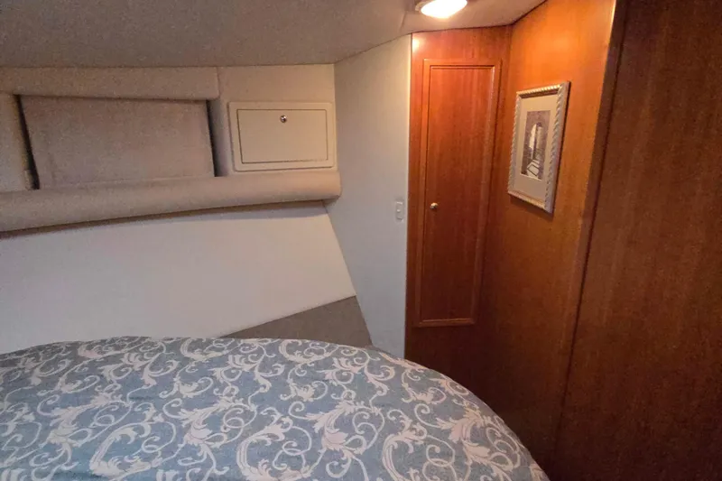 Buenos Aires Yacht Photos Pics Cozy bedroom interior of 2003 Riviera 48 Flybridge yacht with elegant wood paneling.