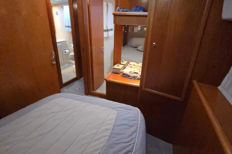 Buenos Aires Yacht Photos Pics 2003 Riviera 48 Flybridge cabin interior with wooden finish and cozy bedding.