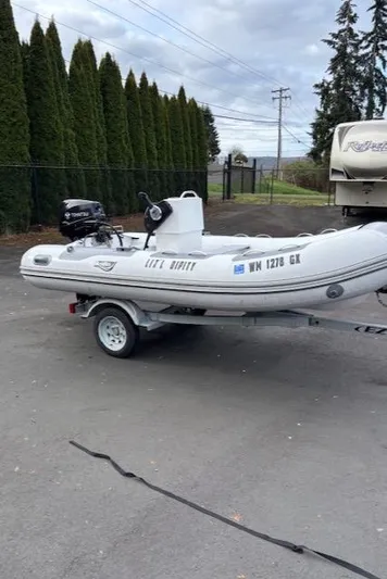  Yacht Photos Pics 2005 Meridian PILOTHOUSE inflatable boat on trailer, parked outdoors.