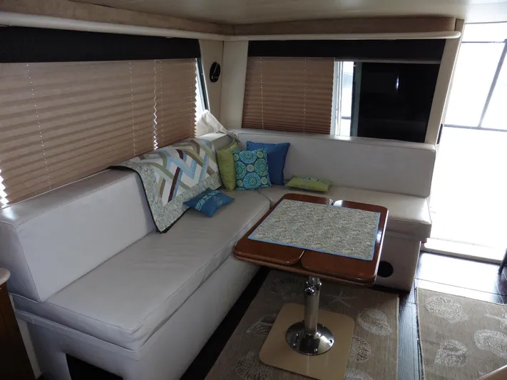  Yacht Photos Pics 2005 Meridian PILOTHOUSE interior with white seating, decorative pillows, and a wooden table.