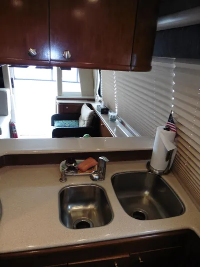  Yacht Photos Pics 2005 Meridian PILOTHOUSE kitchen with dual sinks, wooden cabinets, and a cozy seating area.