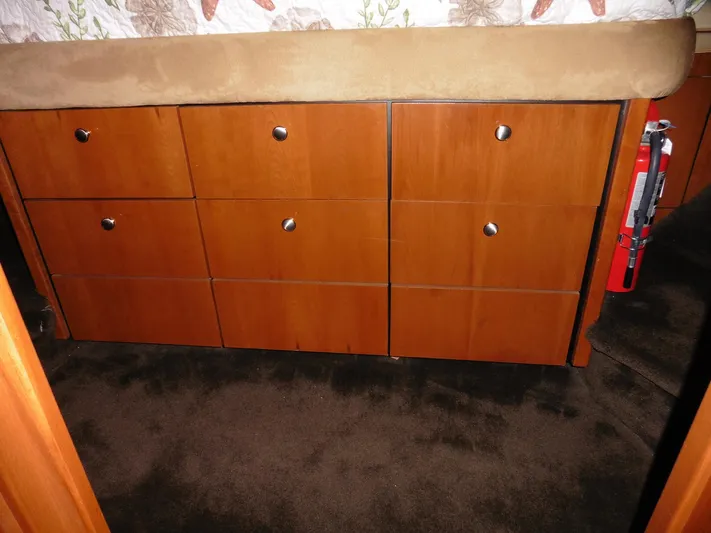  Yacht Photos Pics Wooden drawers in a 2005 Meridian PILOTHOUSE, featuring a carpeted floor and bed above.