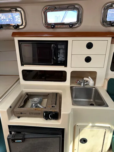  Yacht Photos Pics 2006 Albin 28 Tournament Express galley with stove, sink, microwave, and storage drawers.