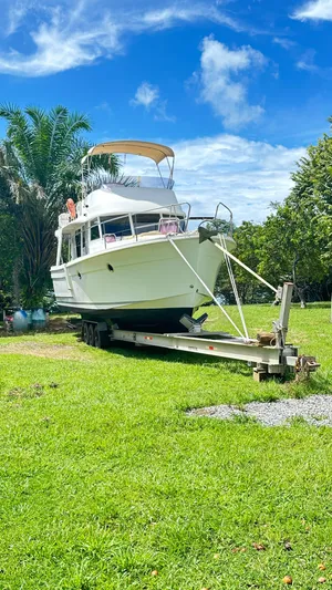  Yacht Photos Pics 2009 Beneteau Swift Trawler 34 on trailer, parked on lush green grass under a clear blue sky.
