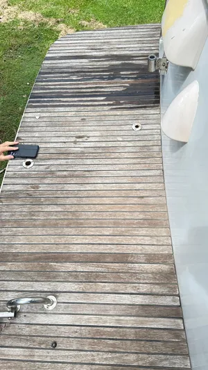  Yacht Photos Pics Beneteau Swift Trawler 34, 2009, wooden deck with metal fixtures and a person holding a phone.