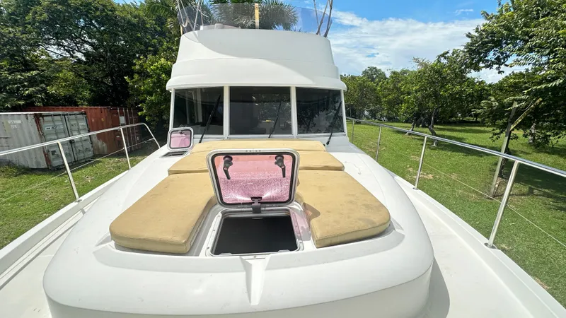  Yacht Photos Pics 2009 Beneteau Swift Trawler 34 with open hatch and sun pads on deck, surrounded by greenery.