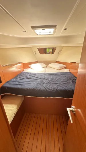  Yacht Photos Pics Cozy cabin interior of 2009 Beneteau Swift Trawler 34 with wooden flooring and double bed.