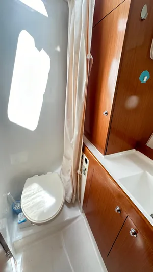 Yacht Photos Pics Bathroom interior of 2009 Beneteau Swift Trawler 34 with wooden cabinetry and white fixtures.