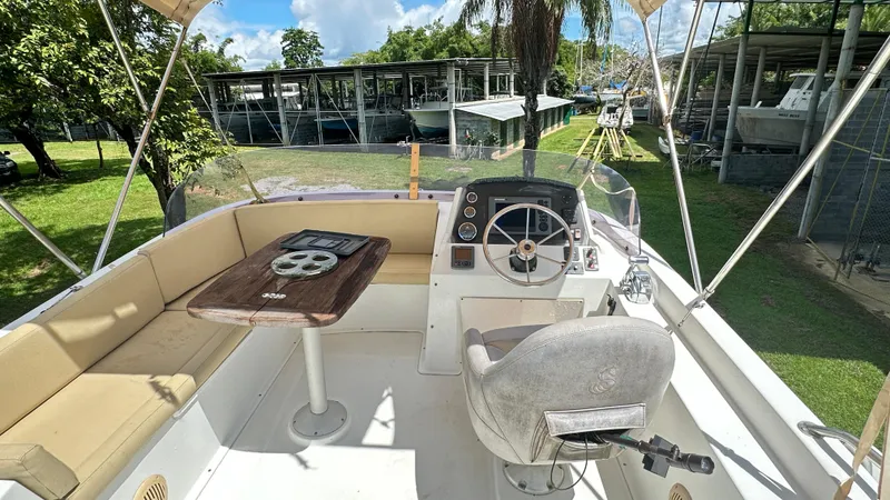  Yacht Photos Pics 2009 Beneteau Swift Trawler 34 cockpit with seating, steering wheel, and table under canopy.