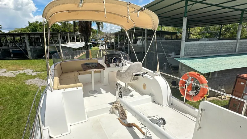  Yacht Photos Pics 2009 Beneteau Swift Trawler 34 with outdoor seating and helm, docked under a canopy.