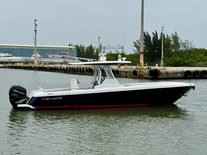  Yacht Photos Pics 2018 Intrepid 327 Center Console boat on calm water near a dock.