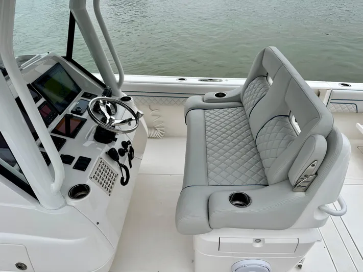  Yacht Photos Pics 2018 Intrepid 327 Center Console boat interior with steering wheel and cushioned seating.